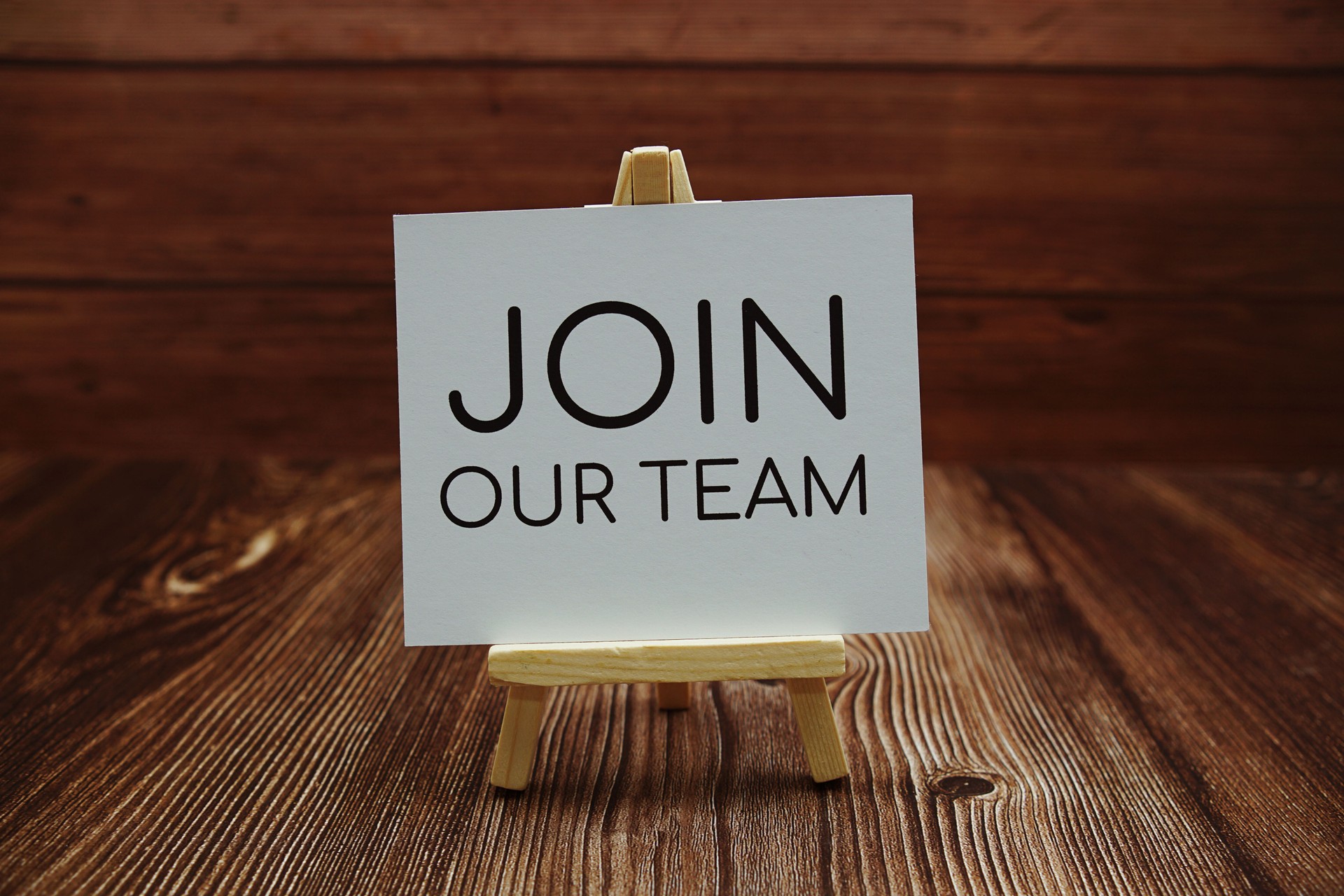 Join Our Team text on paper card on wooden background
